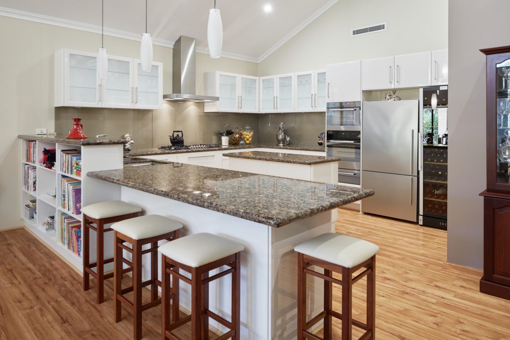 open plan kitchen with white and wooden bar stools